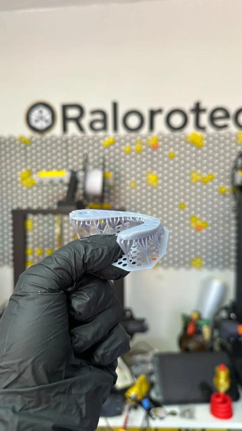 Arco dental impreso en resina con soportes, sostenido en el taller Ralorotech en Guadalajara