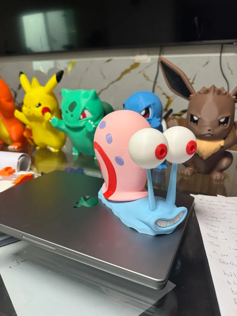 Varias figuras de Gary y pokemons impresas en 3D sobre laptop; muestra de piezas y acabados para proyectos creativos