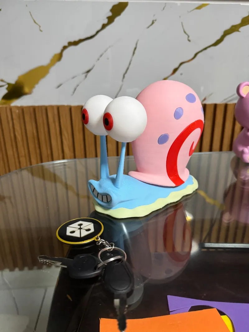 Figura de Gary de Bob Esponja impresas en 3D sobre mesa de cristal; ejemplo de acabado y color en pieza decorativa